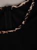 Czarna sukienka z wzorzystymi lamówkami 18584, kreacja w rozkloszowanym fasonie.