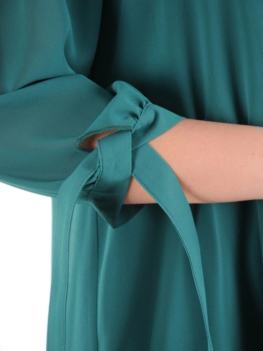 Butelkowozielona sukienka trapezowa na andrzejki i wesele – tuszujący fason z kontrafałdą 39514