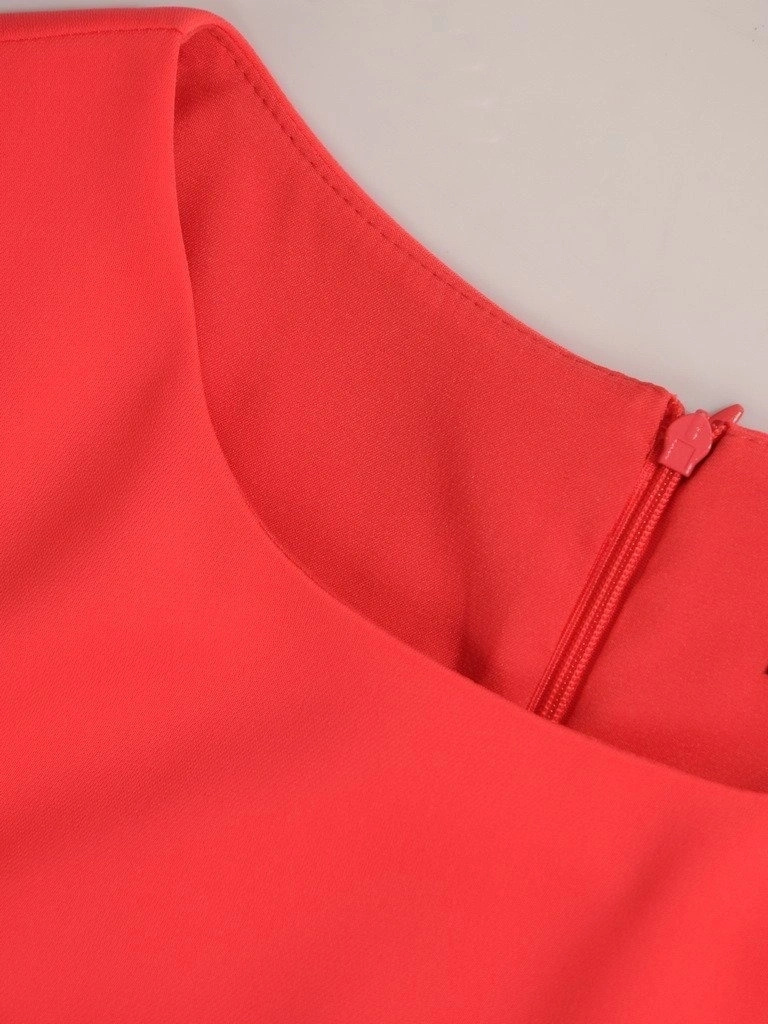 Elegancka koralowa sukienka trapezowa z czarną koronką – swobodny fason z dekoracyjną falbaną 21475