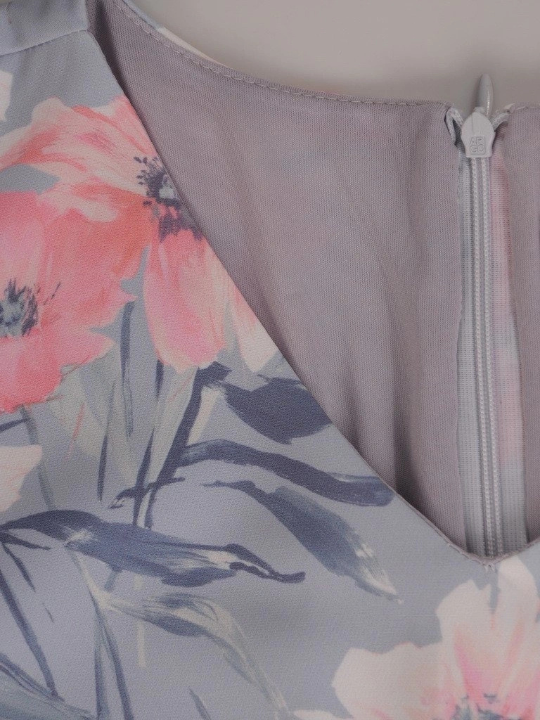 Pastelowa sukienka trapezowa w kwiaty – wysmuklający fason z urokliwą falbaną na rękawie 19532