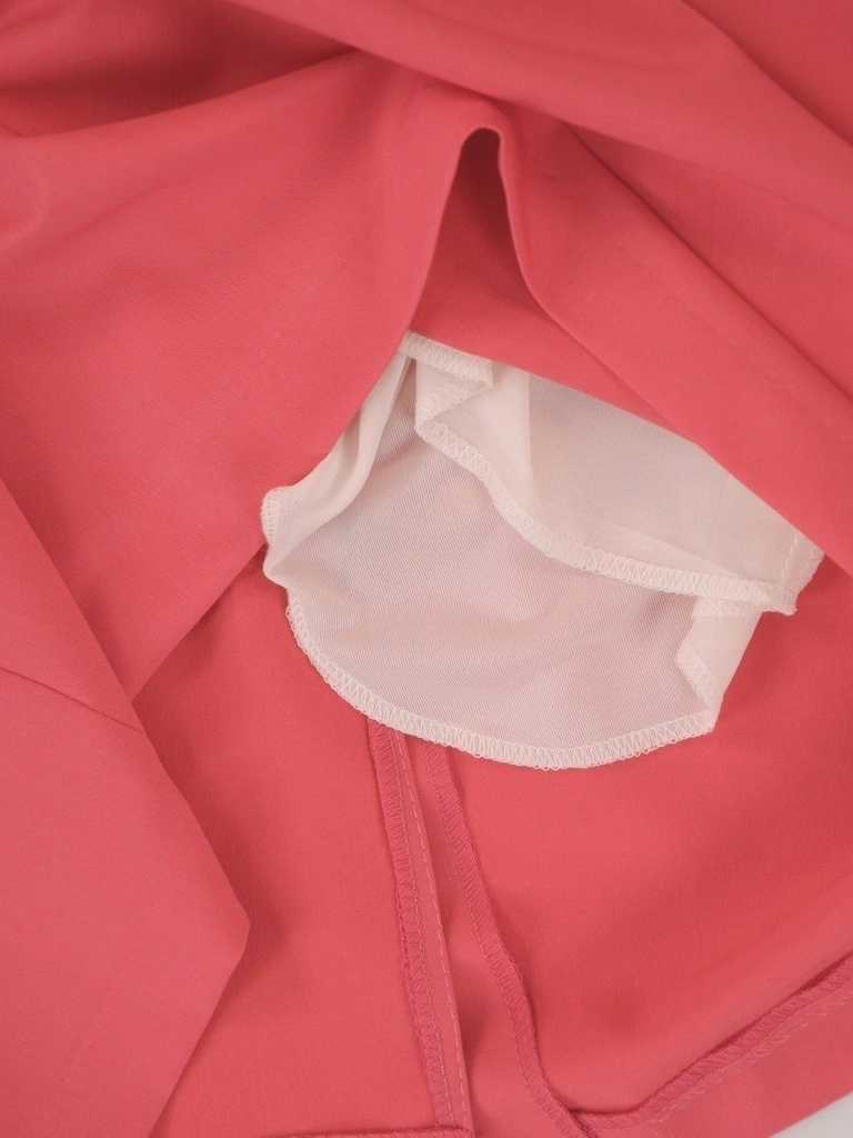 Elegancka koralowa sukienka midi z dekoltem serek – prosty krój z ozdobną broszką 37713